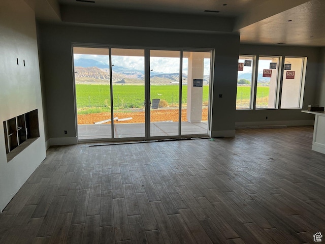 4810 W 1930 S, Hurricane, UT 84737 - unfurnished living room with dark wood finished floors, baseboards, a mountain view, and plenty of natural light