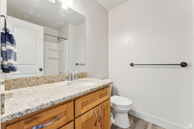 full bath with baseboards, toilet, wood finished floors, vanity, and a shower