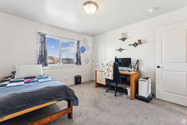 carpeted bedroom featuring baseboards and a textured ceiling