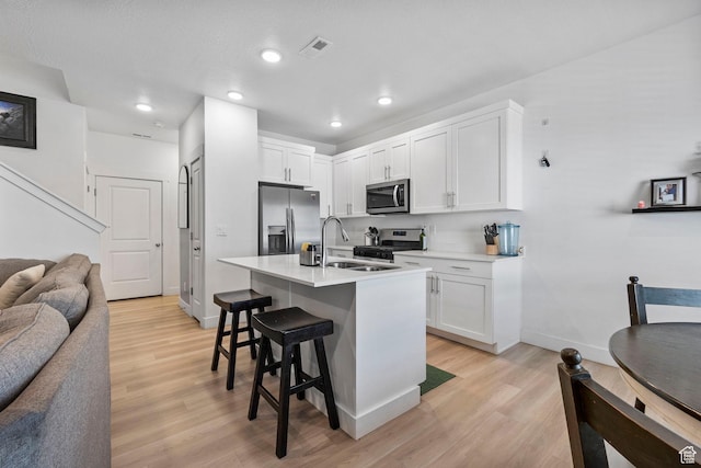 899 N 1330 E, Spanish Fork, UT 84660 - kitchen featuring a sink, light wood-style floors, appliances with stainless steel finishes, a kitchen bar, and open floor plan