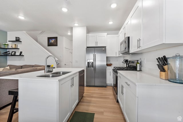 899 N 1330 E, Spanish Fork, UT 84660 - kitchen with light wood-type flooring, a center island with sink, a sink, appliances with stainless steel finishes, and white cabinets