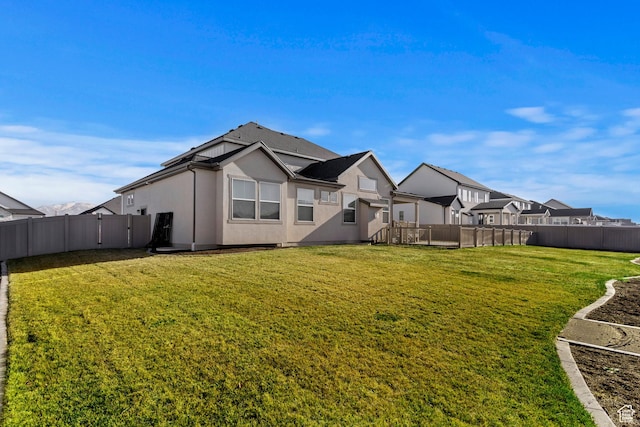 1251 N 2525 W, Clinton, UT 84015 - back of house featuring a lawn, a fenced backyard, and stucco siding