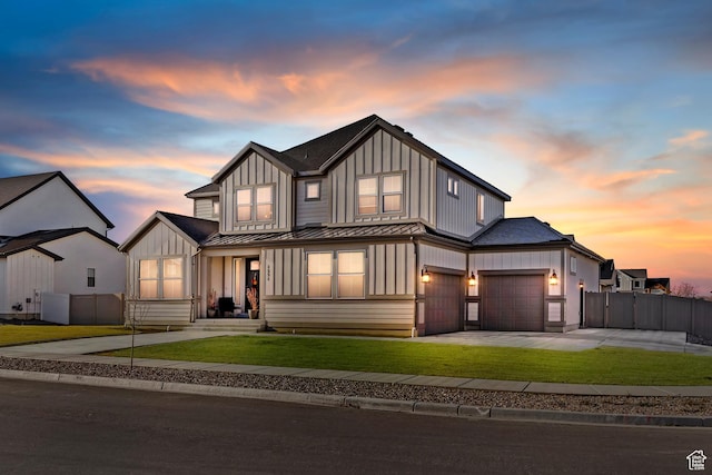 modern inspired farmhouse with board and batten siding, driveway, a front yard, and fence