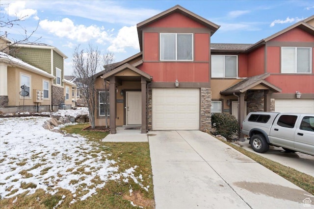 view of front facade featuring concrete driveway, an attached garage, stone siding, and stucco siding