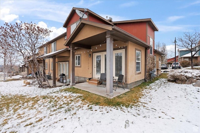 14488 S Stone Stream St W, Herriman, UT 84096 - snow covered back of property with entry steps, a patio area, and stucco siding