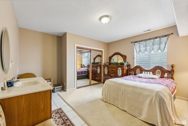 710 E Ridge Crest Ct S, Alpine, UT 84004 - bedroom featuring light tile patterned floors, visible vents, a sink, a closet, and a textured ceiling