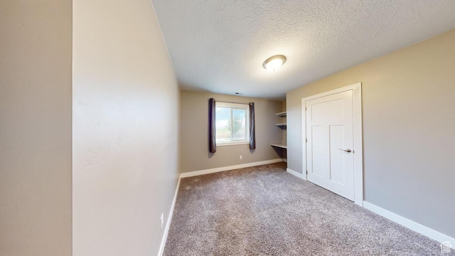 unfurnished bedroom with baseboards, carpet floors, and a textured ceiling