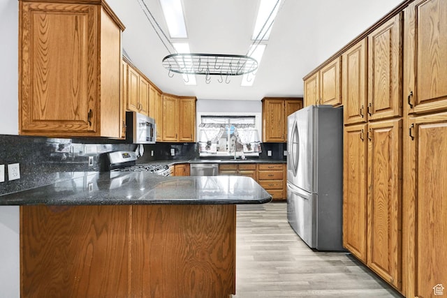 1461 E Antelope Dr, Layton, UT 84040 - kitchen featuring a peninsula, light wood finished floors, appliances with stainless steel finishes, and decorative backsplash