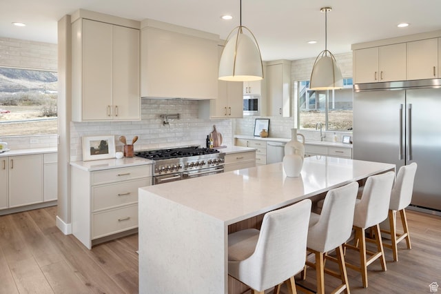 882 E 740 S, Salem, UT 84653 - kitchen with built in appliances, backsplash, light wood-type flooring, a center island, and a kitchen bar
