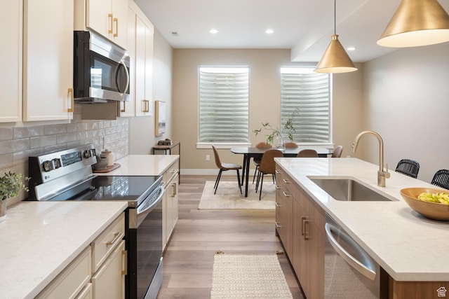 882 E 740 S, Salem, UT 84653 - kitchen with appliances with stainless steel finishes, a sink, light wood finished floors, a kitchen island with sink, and backsplash