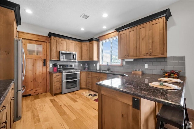 29125 N 11090 E, Fairview, UT 84629 - kitchen featuring a peninsula, light wood-style flooring, a sink, visible vents, and appliances with stainless steel finishes