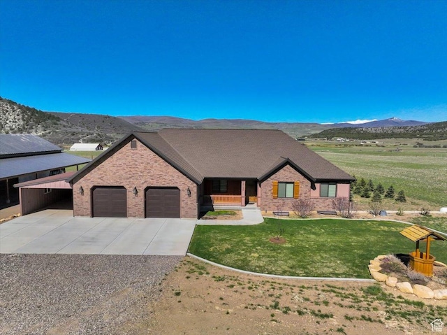 29125 N 11090 E, Fairview, UT 84629 - view of front of house featuring a mountain view, brick siding, driveway, a garage, and a front lawn