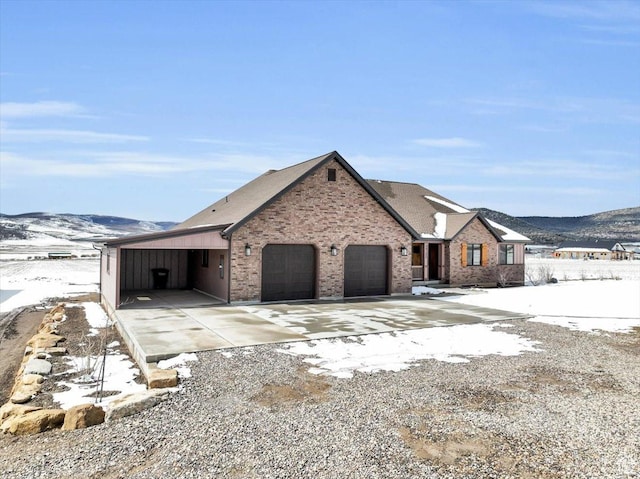 29125 N 11090 E, Fairview, UT 84629 - view of front of house featuring an attached garage, a mountain view, brick siding, and driveway