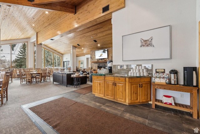 kitchen with open floor plan, wood ceiling, beam ceiling, a fireplace, and high vaulted ceiling