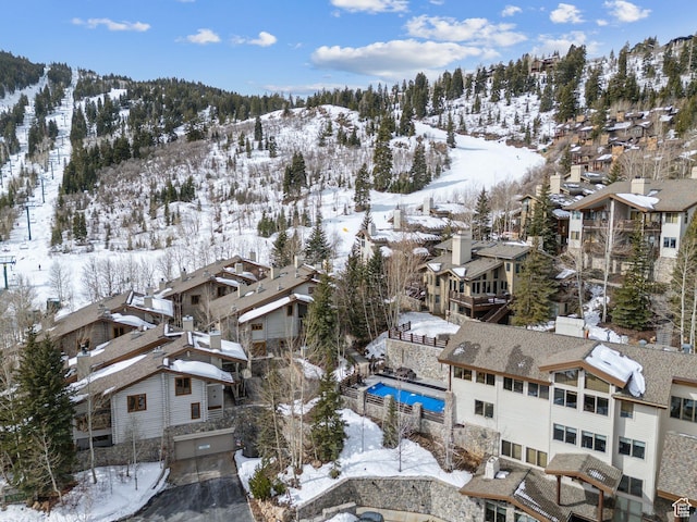 snowy aerial view with a mountain view and a residential view