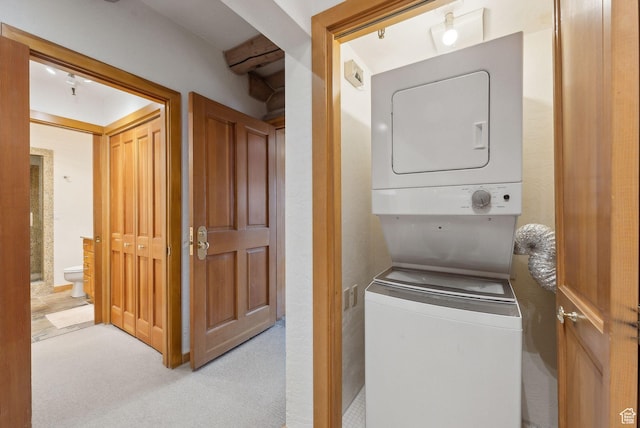 washroom featuring carpet floors and stacked washing maching and dryer
