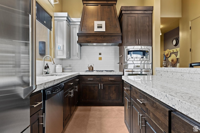 2139 W Cougar Rock Cir S Unit 135, St George, UT 84770 - kitchen featuring premium range hood, appliances with stainless steel finishes, a sink, light stone countertops, and tasteful backsplash
