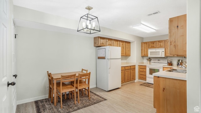 3477 E Rdg Route Rd Unit 5, Eagle Mountain, UT 84005 - kitchen featuring an inviting chandelier, light countertops, a sink, white appliances, and light wood-style flooring