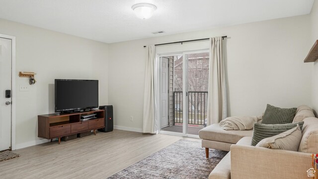 3477 E Rdg Route Rd Unit 5, Eagle Mountain, UT 84005 - living room with wood finished floors, visible vents, and baseboards