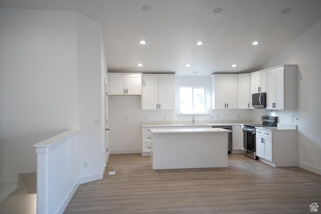 2277 E 3530 N Unit 511, Eagle Mountain, UT 84005 - kitchen with light wood-type flooring, a center island, white cabinetry, recessed lighting, and stainless steel appliances