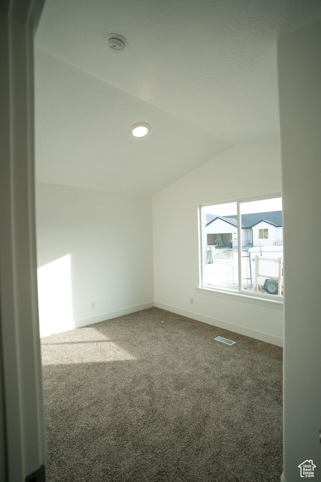 2277 E 3530 N Unit 511, Eagle Mountain, UT 84005 - unfurnished room featuring visible vents, lofted ceiling, baseboards, and carpet flooring