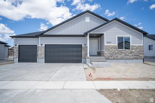 view of front of house featuring board and batten siding, concrete driveway, a garage, and stone siding