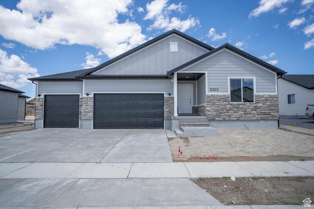 2277 E 3530 N Unit 511, Eagle Mountain, UT 84005 - view of front of home with board and batten siding, concrete driveway, a garage, and stone siding