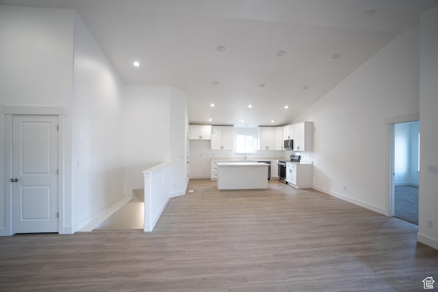 2277 E 3530 N Unit 511, Eagle Mountain, UT 84005 - kitchen with white cabinets, light wood-type flooring, open floor plan, and stainless steel appliances