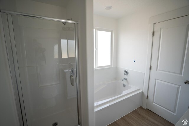 2277 E 3530 N Unit 511, Eagle Mountain, UT 84005 - bathroom featuring wood finished floors, a stall shower, and a bath