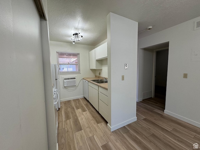 5630 S Meadow Ln Unit 197, South Ogden, UT 84403 - kitchen featuring white cabinetry, a wall mounted AC, a sink, dishwasher, and light wood-style flooring