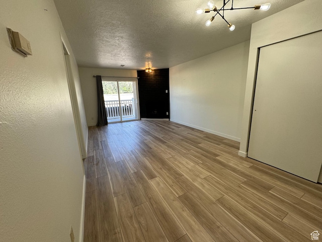 5630 S Meadow Ln Unit 197, South Ogden, UT 84403 - unfurnished room with a textured ceiling, wood finished floors, baseboards, and a chandelier
