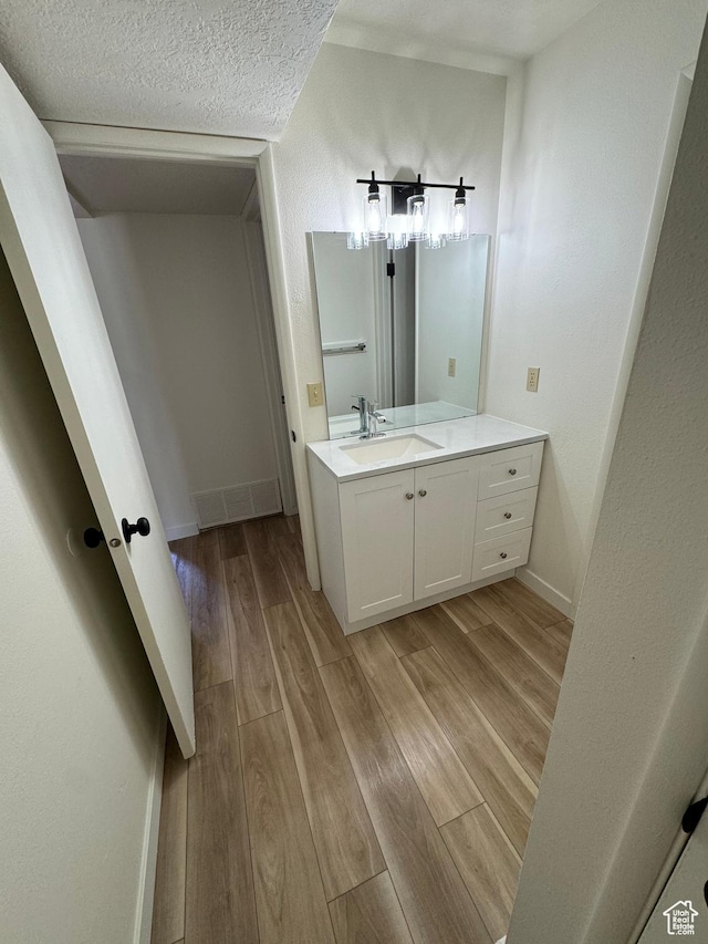 5630 S Meadow Ln Unit 197, South Ogden, UT 84403 - bathroom with vanity, a textured ceiling, baseboards, and wood finished floors