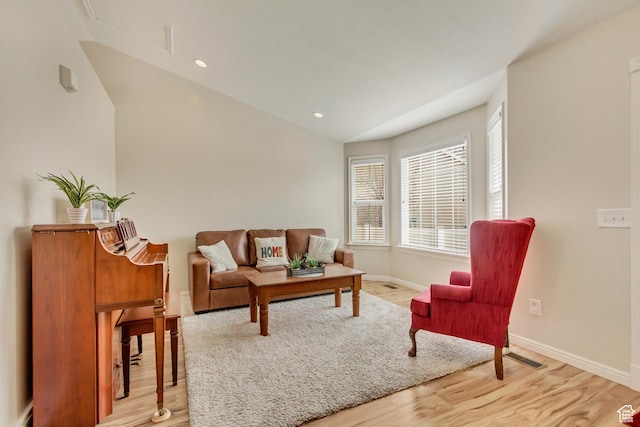 living room with recessed lighting, light wood-style floors, vaulted ceiling, and baseboards