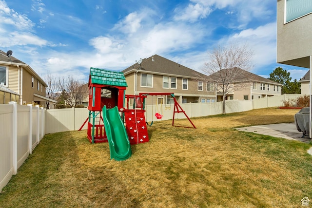 view of jungle gym featuring a lawn and a fenced backyard