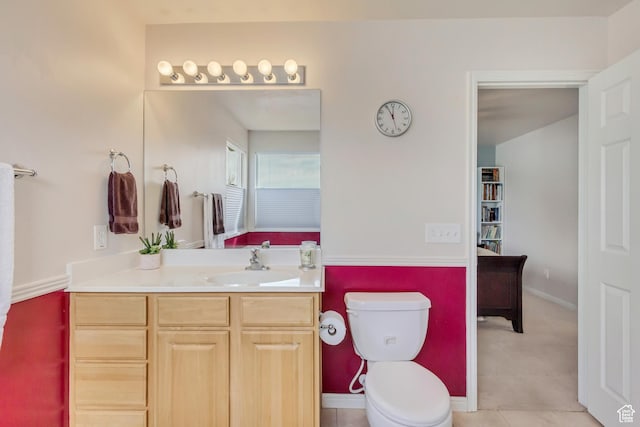 bathroom featuring baseboards, toilet, and vanity