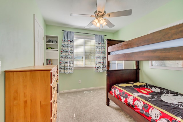 bedroom with light colored carpet, ceiling fan, baseboards, and visible vents