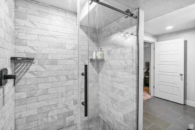 5131 N Stratford Dr W, Stansbury Park, UT 84074 - bathroom with baseboards, recessed lighting, a textured ceiling, and a stall shower