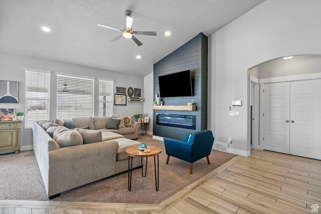 5131 N Stratford Dr W, Stansbury Park, UT 84074 - living area with a ceiling fan, wood finished floors, arched walkways, a large fireplace, and baseboards