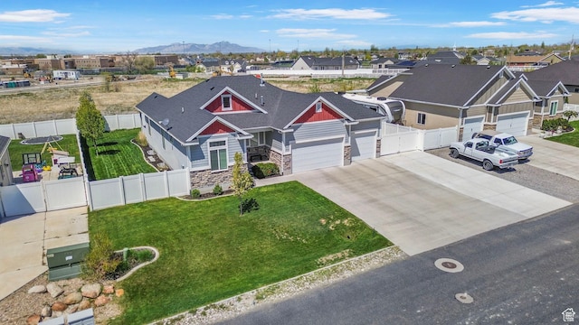 5131 N Stratford Dr W, Stansbury Park, UT 84074 - view of front of home with a residential view, an attached garage, driveway, stone siding, and a mountain view