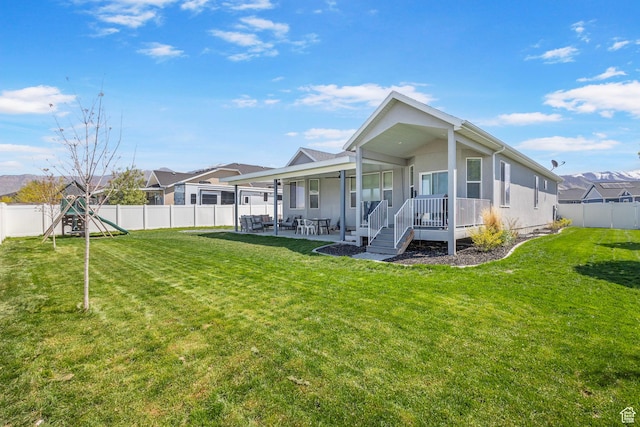5131 N Stratford Dr W, Stansbury Park, UT 84074 - rear view of house with a fenced backyard, a patio area, a yard, and stucco siding