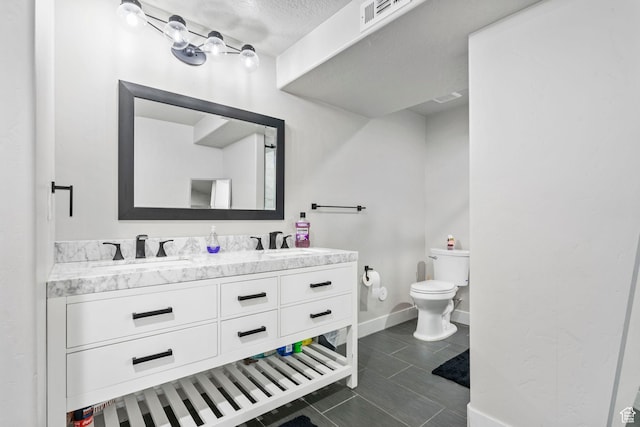 5131 N Stratford Dr W, Stansbury Park, UT 84074 - bathroom featuring double vanity, toilet, baseboards, and a sink