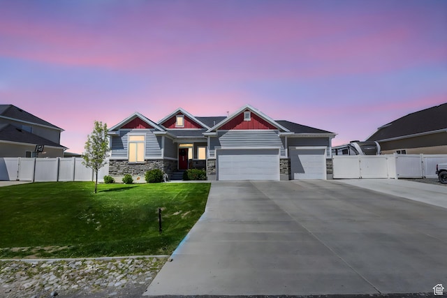 5131 N Stratford Dr W, Stansbury Park, UT 84074 - craftsman-style home featuring fence, a front lawn, driveway, stone siding, and a garage