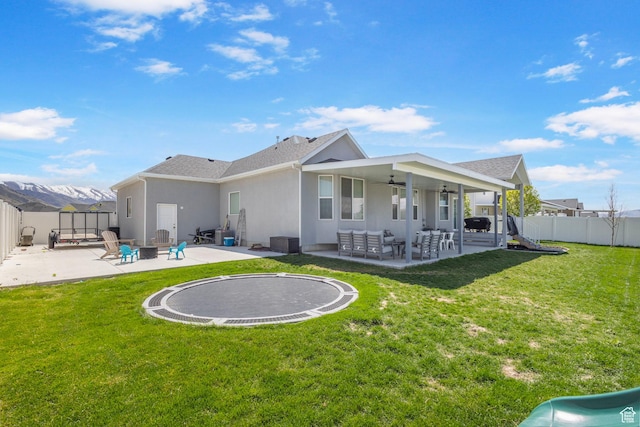 5131 N Stratford Dr W, Stansbury Park, UT 84074 - back of property featuring a lawn, a fenced backyard, and a patio