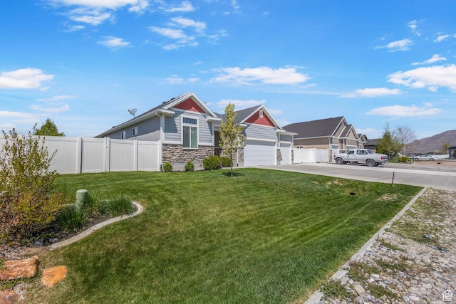 5131 N Stratford Dr W, Stansbury Park, UT 84074 - view of front of home featuring stone siding, driveway, fence, and a front yard
