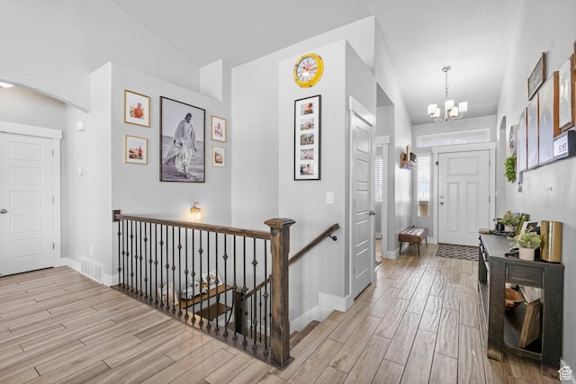 5131 N Stratford Dr W, Stansbury Park, UT 84074 - foyer with a chandelier, light wood-type flooring, baseboards, lofted ceiling, and visible vents