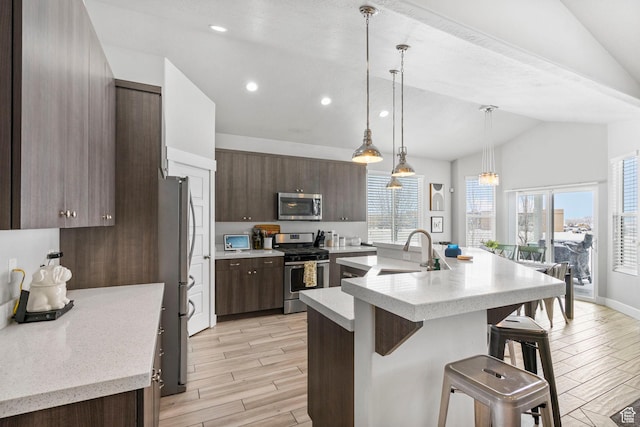 5131 N Stratford Dr W, Stansbury Park, UT 84074 - kitchen featuring vaulted ceiling, light countertops, a sink, and appliances with stainless steel finishes