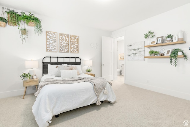 bedroom with baseboards, carpet, and ensuite bath