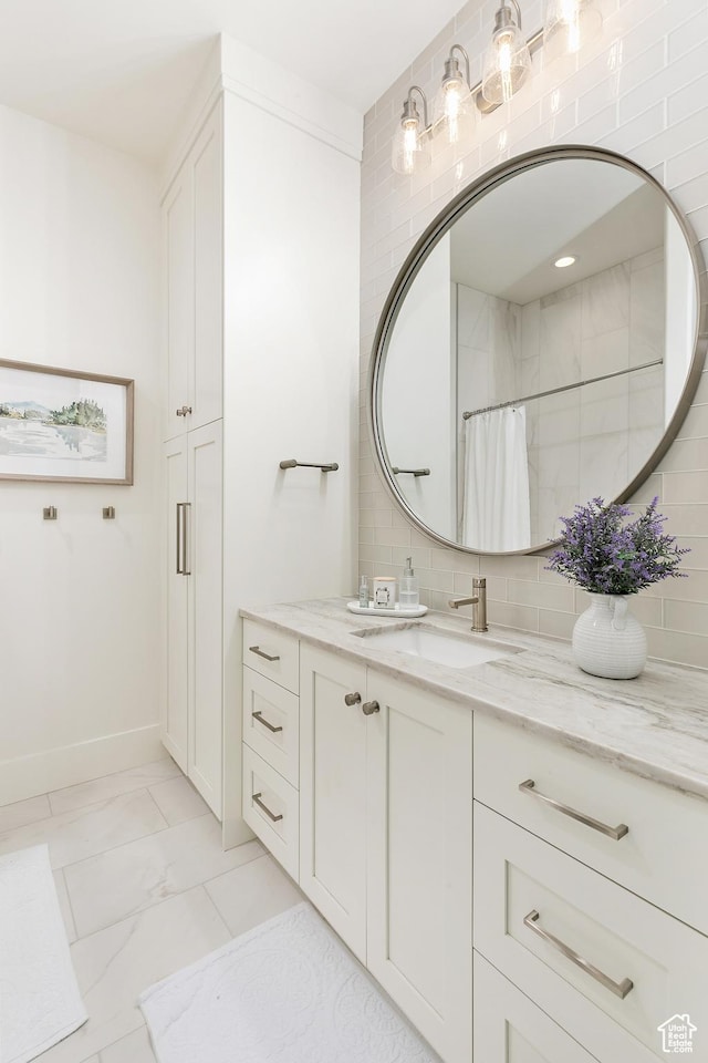 bathroom featuring vanity, baseboards, curtained shower, marble finish floor, and backsplash