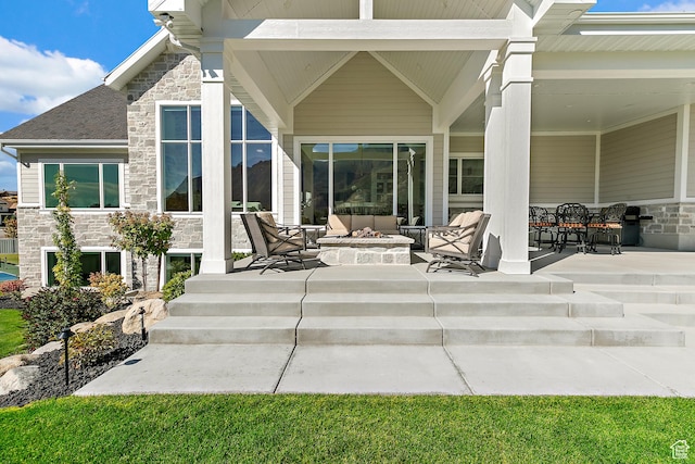 view of patio with an outdoor living space with a fire pit