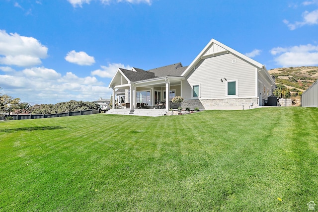 rear view of property with a patio, a yard, and fence